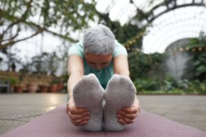 An older woman stretching as part of yoga, highlighting the benefits of stretching for older adults