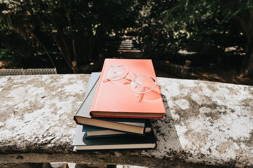 A small pile of books outside, highlighting the best books for dementia caregivers