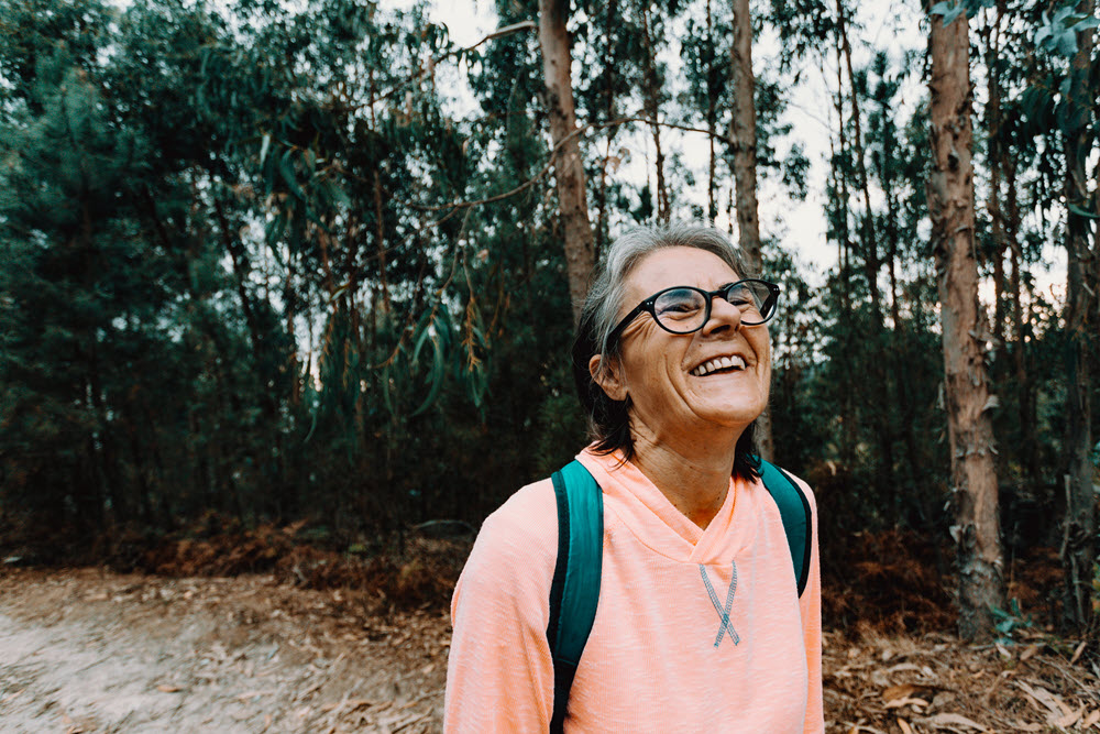 A smiling senior woman outside, promoting the idea of mental health