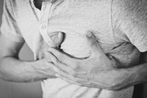 A man holding his heart, highlighting the idea of a heart disease misdiagnosis