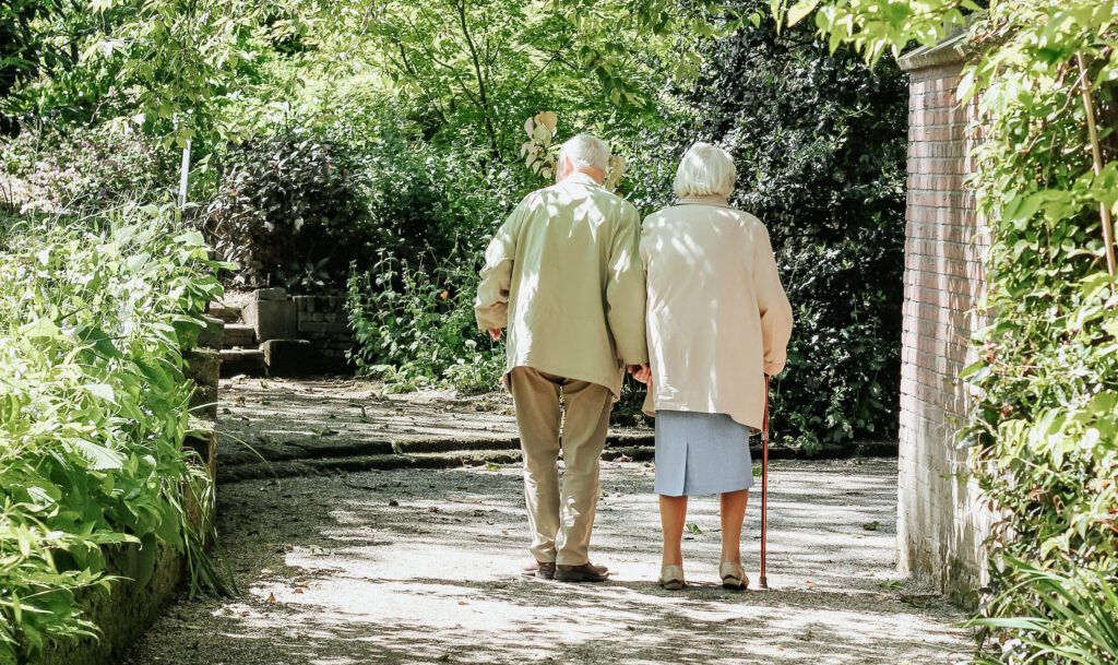 Two seniors walking outside, highlighting the idea of romance and STDs in nursing homes