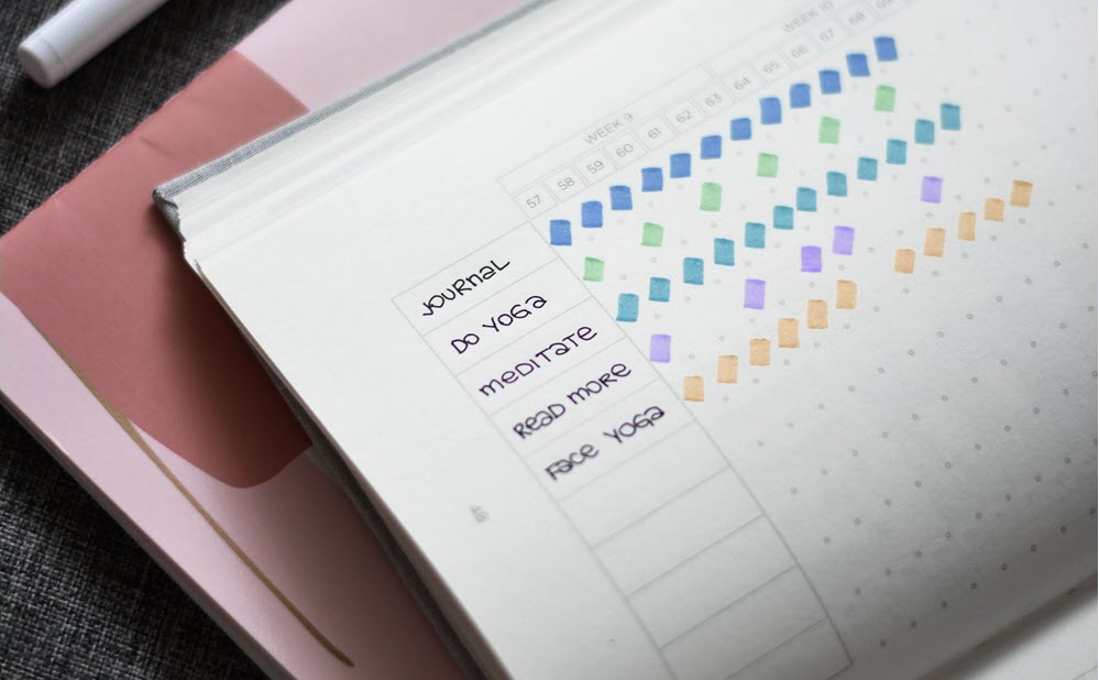 Someone using a bullet journal to track healthy habits for caregivers