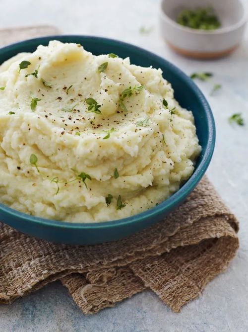 A large blue dish with mashed cauliflower and thyme