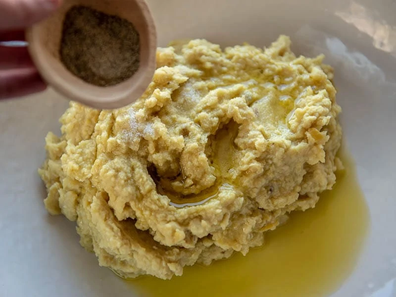 A fava bean puree with olive oil being poured over it