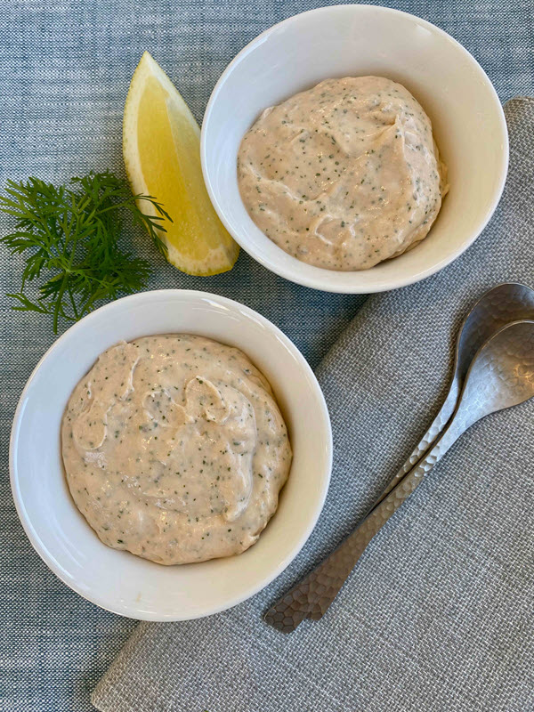 Two white bowls containing pureed salmon with dill and cream cheese