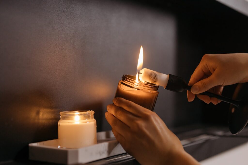 Someone lighting a candle, highlighting the idea of faith and spirituality