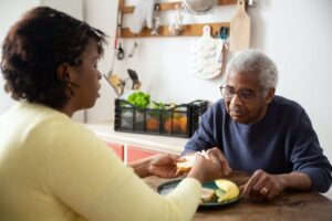 A home health worker helping a senior with his food