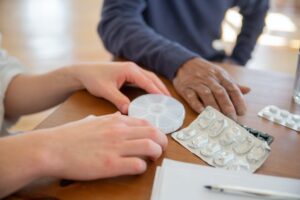 A nurse helping a senior with medication