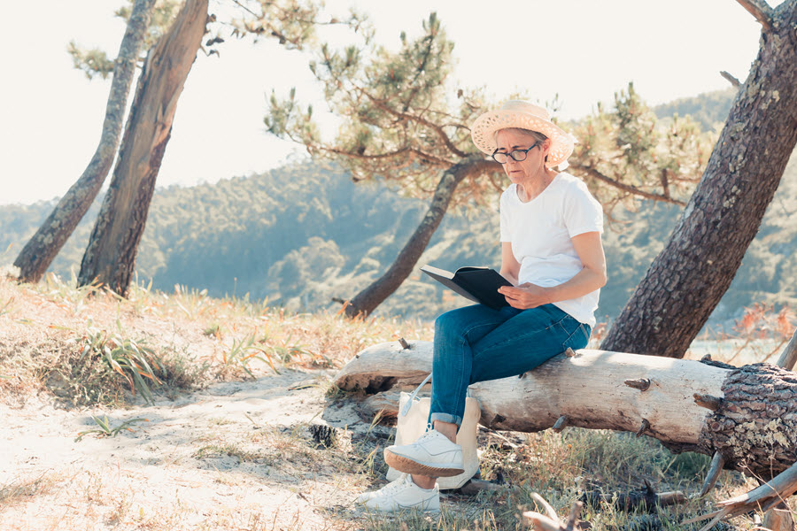 A woman sitting outside with a book