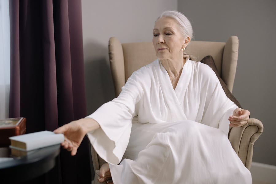 An elegant older woman with a book