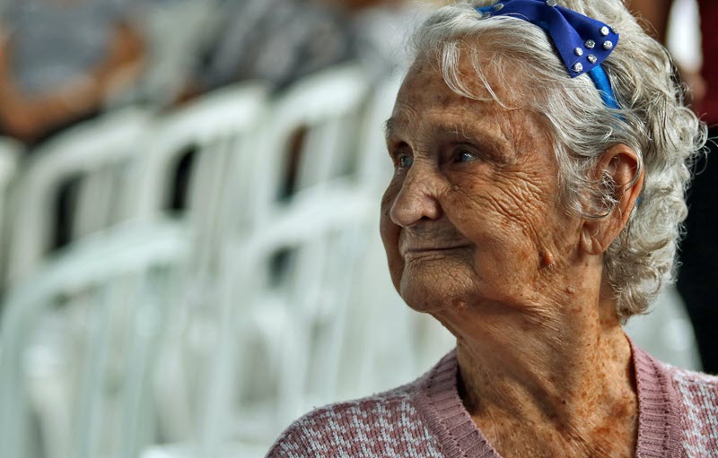 An older woman wearing a blue headband looking away from the camera