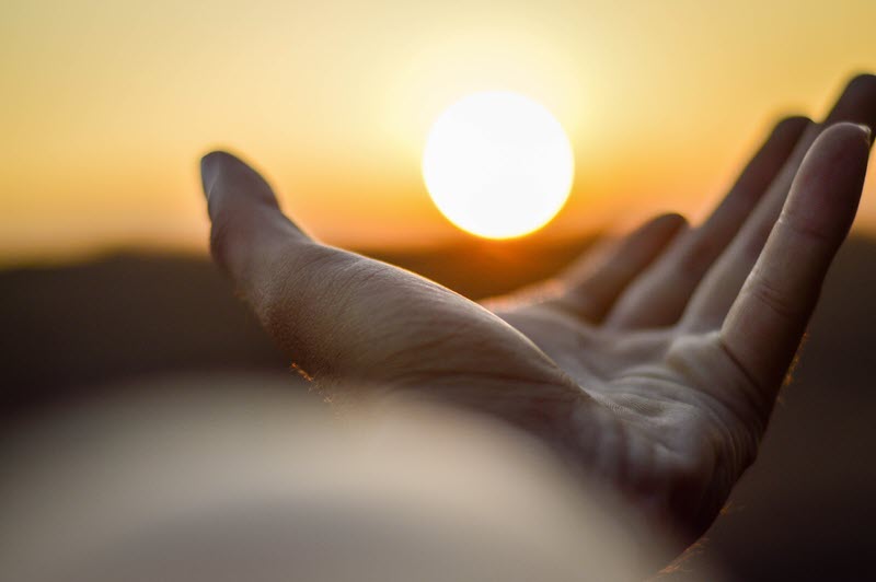 Someones outstretched palm near the sun