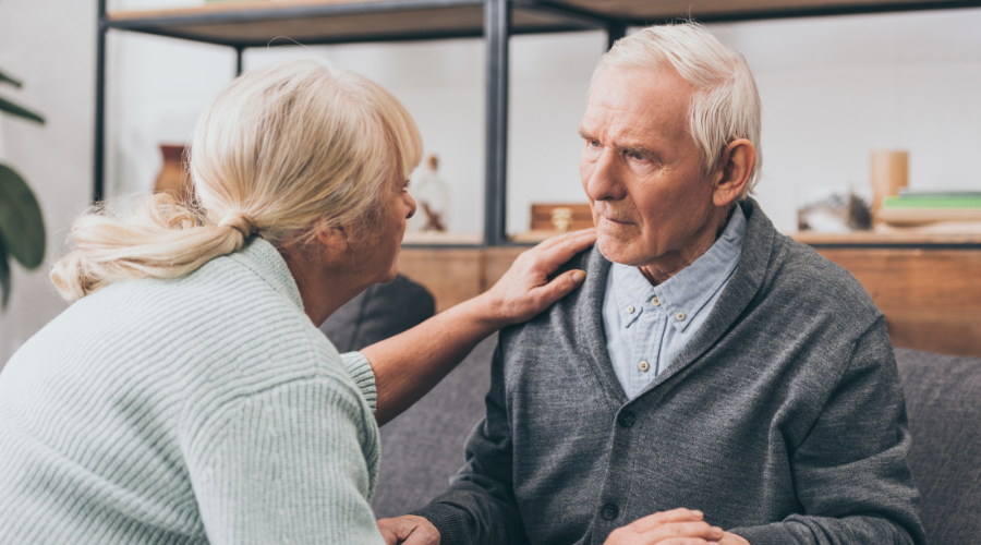 An older woman talking to a man, highlighting the question of do people with dementia know they have it?