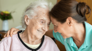 An older woman with dementia and her caregiver