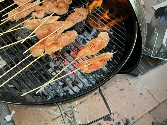 A close up image of chicken on coals