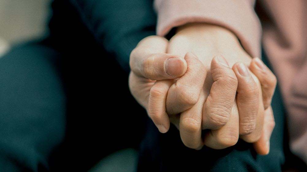 A pair of clasping hands, highlighting the idea of caregiver support