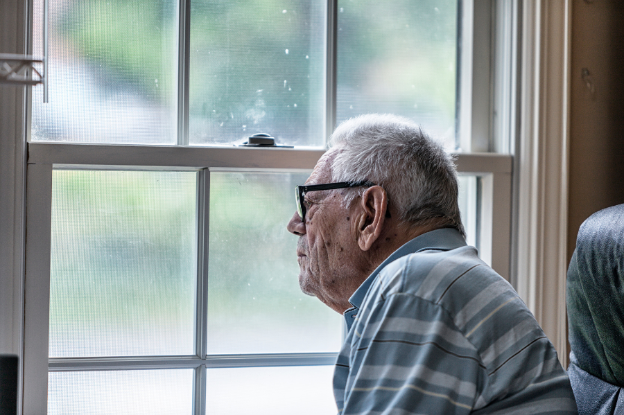 A sad man with dementia sitting in a chair, looking at the question of - do dementia patients know they are dying?