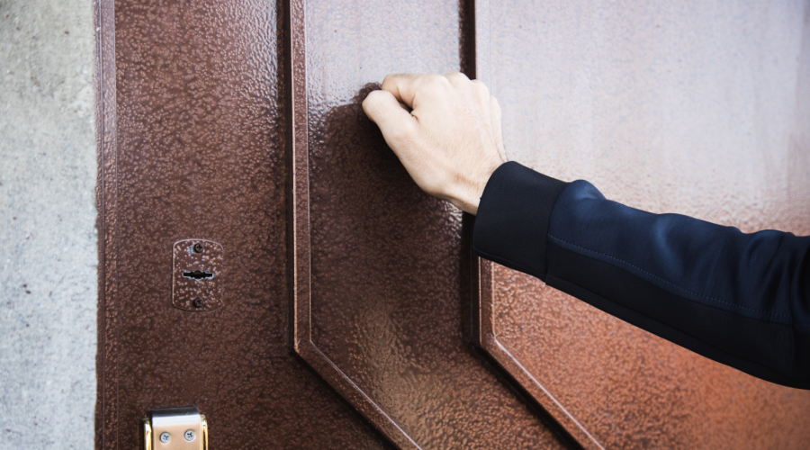 Someone knocking on a house door, highlighting the question of - can a sibling prevent you from seeing an elderly parent?