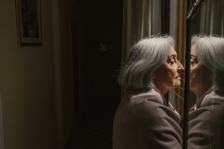 A woman with dementia staring out the window