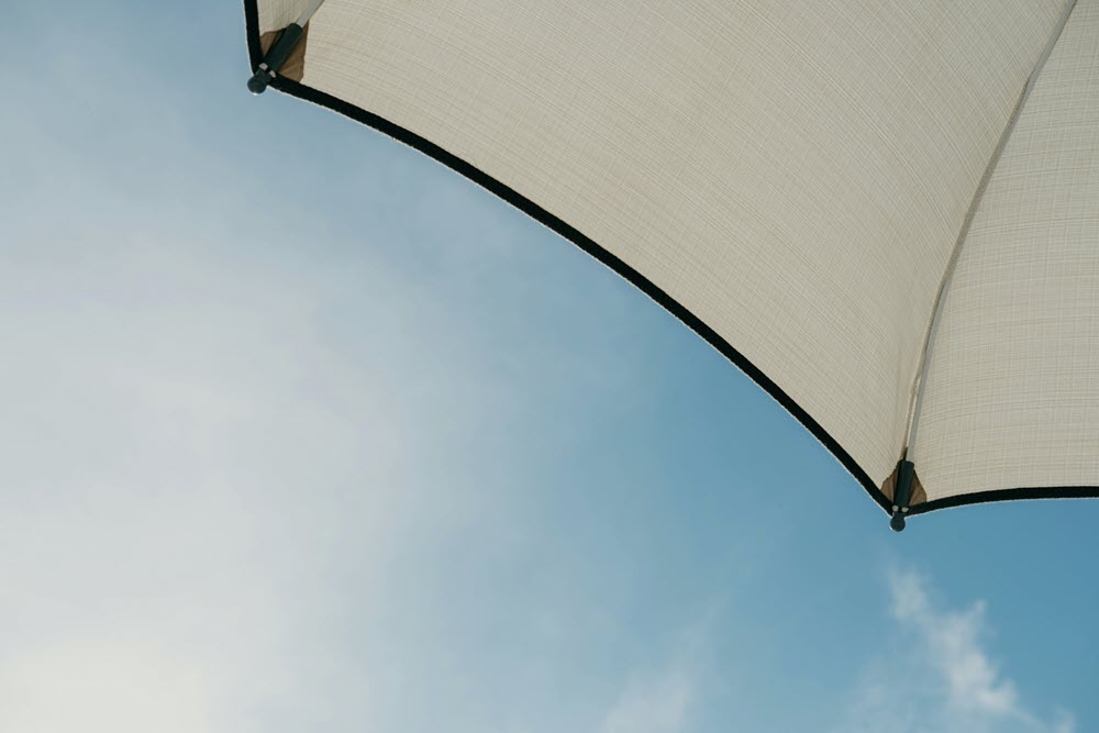 An umbrella and blue skies with clouds