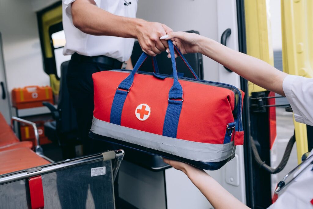 Someone handing a bag of medical supplies from a NMET vehicle