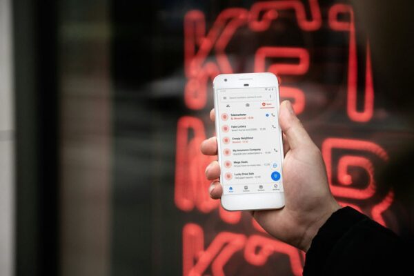 Someone holding a phone that contains messages from a scammer