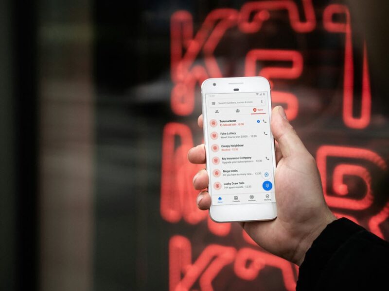 Someone holding a phone that contains messages from a scammer