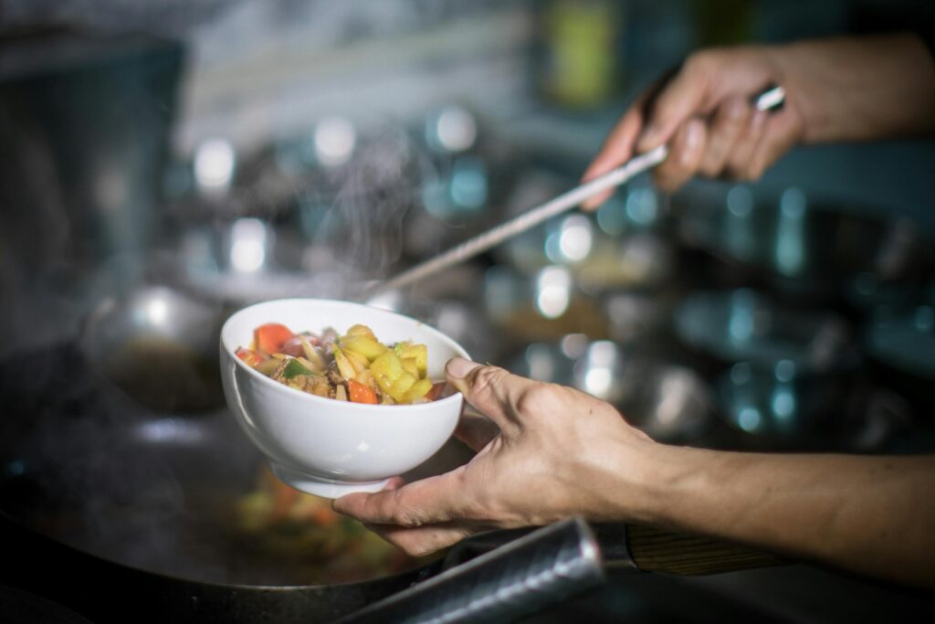 A man preparing roast vegetables in a kitchen