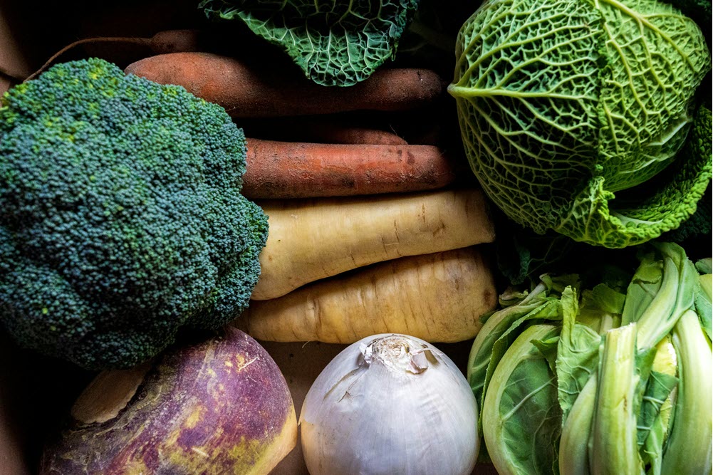 Fresh vegetables from a CSA, including broccoli, parsnip, and carrots