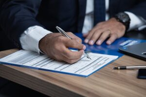 A senior signing a document, highlighting the difference between POLST vs living wills