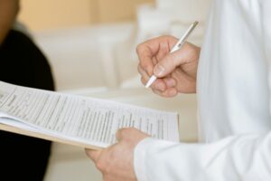 Someone signing paperwork in a hospital, highlighting the idea of decision making in seniors