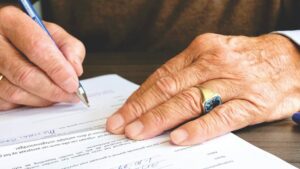 Someone signing their advance care paperwork, highlighting the various types of advance directives in Arizona