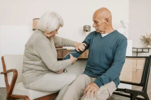 An older woman acting as a caregiver for her spouse